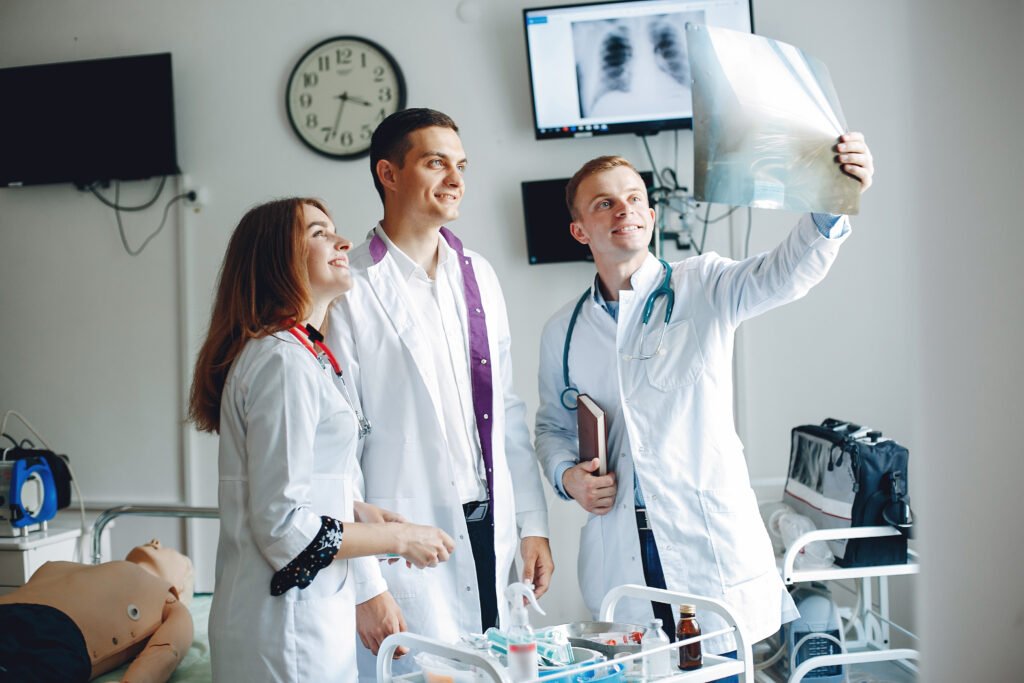 Three interns examine the x-ray in the hospital room.